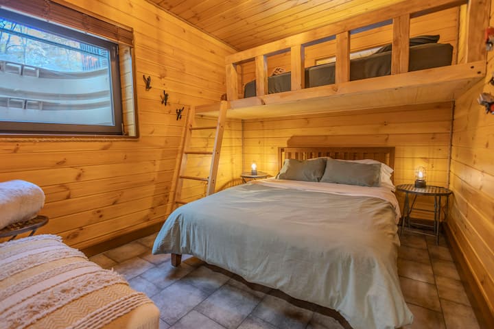 上下铺式布局，下铺为一张 1.8 米宽双人床，上铺为一张单人床。