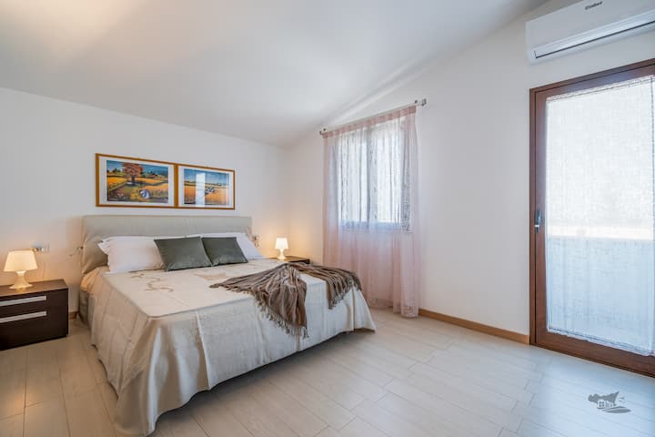 El luminoso y acogedor dormitorio del primer piso con acceso al balcón. La habitación cuenta con una acogedora cama doble y una suave luz natural, lo que crea el espacio perfecto para relajarte y disfrutar de tu escapada siciliana.