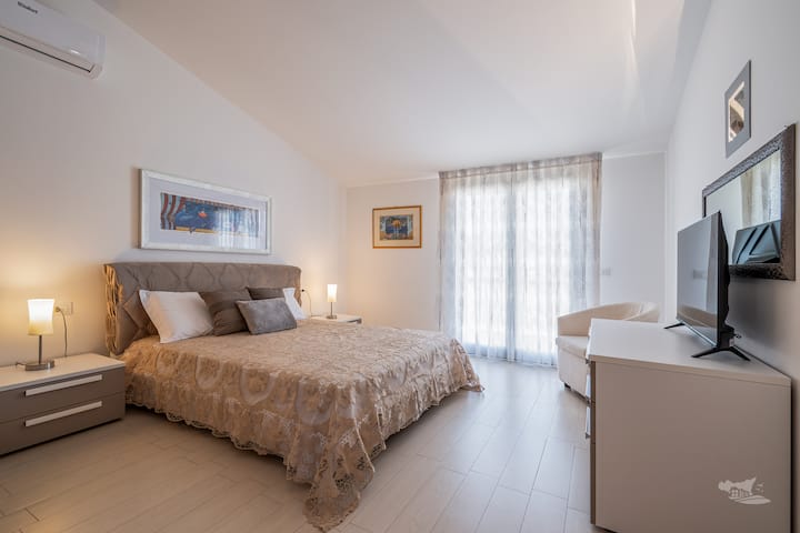 El último dormitorio del primer piso cuenta con una acogedora cama doble, una decoración elegante y acceso directo al balcón. Un espacio sereno y elegante, perfecto para relajarse y disfrutar de la belleza de Sicilia.