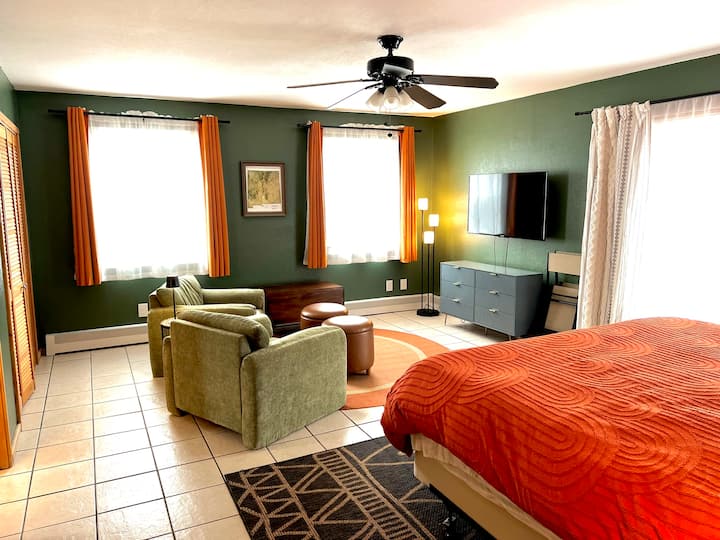 Dormitorio con sala de estar y baño adjunto.