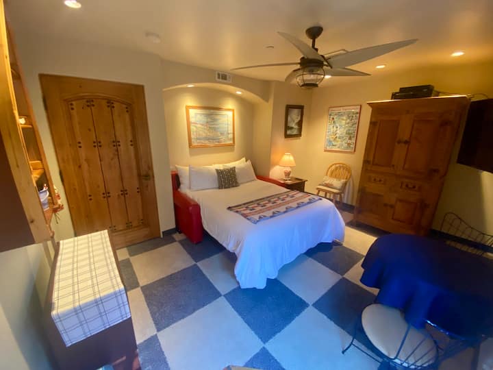 ห้องนอนสไตล์นอติคอลพร้อมเตียงควีนไซส์ที่สะดวกสบายมากพร้อมที่นอนคู่ ตู้เสื้อผ้า ระบบความบันเทิง ห้องน้ำส่วนตัว และประตูไปยังลานด้านหลัง 