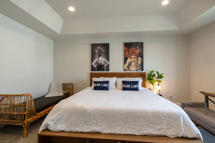 Chambre avec un lit taille King, des coussins décoratifs Bear Lake et de l'art mural au-dessus de la tête de lit.