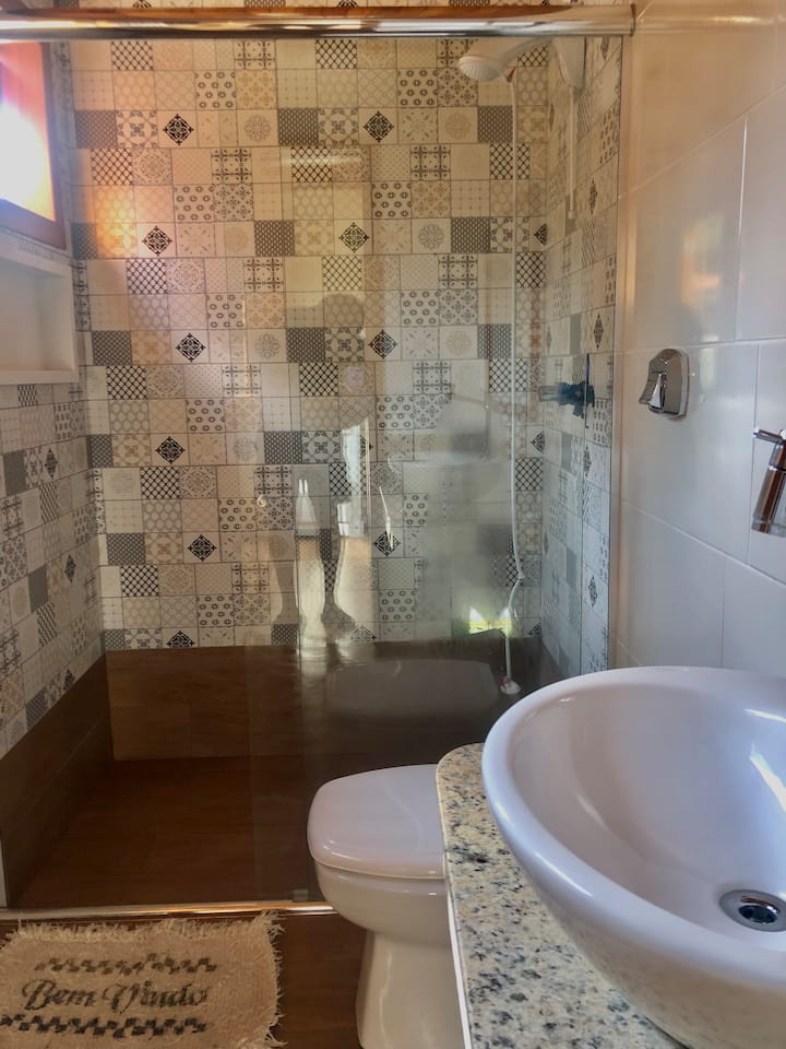 Badkamer met uitzicht op de bamboezels met een douche (gouden douche)