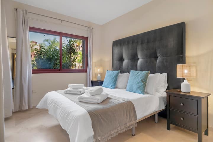 Bright and airy master bedroom with pool views, featuring ensuite bathroom and patio doors that open directly onto the terrace, creating a seamless indoor-outdoor living experience.