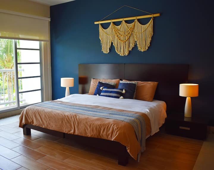 ✨Dhomë gjumi kryesore✨ Dhomë e gjerë dhe elegante me një krevat dopio "king", mur blu të thellë dhe tekstile në tone të ngrohta që krijojnë një atmosferë të sofistikuar dhe komode.