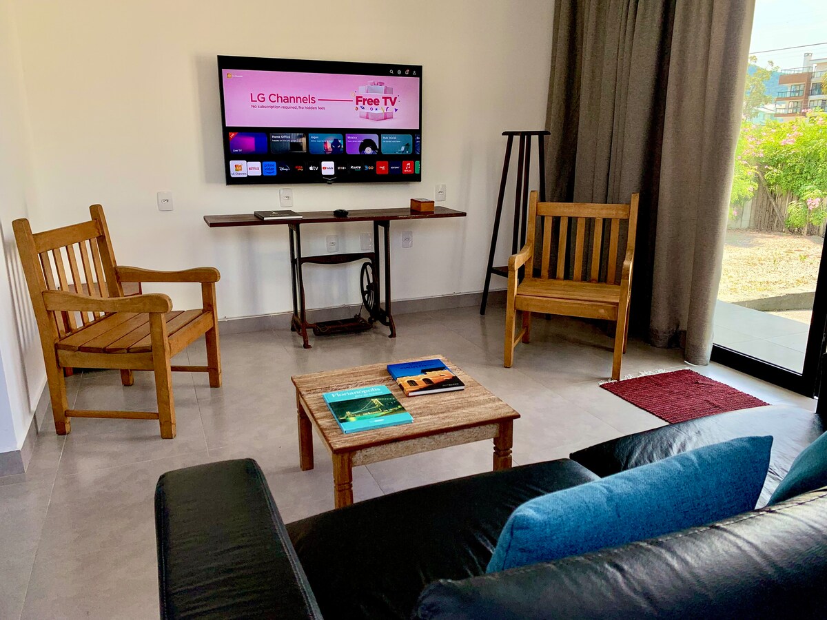 Всекидневна със смарт телевизор, удобна и просторна, с изглед към градината и входната зона