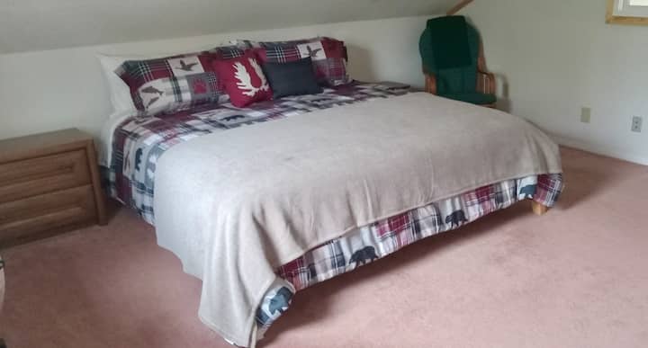 El dormitorio principal incluye una cama tamaño king, espacio de trabajo, mecedora, vestidor y baño privado.