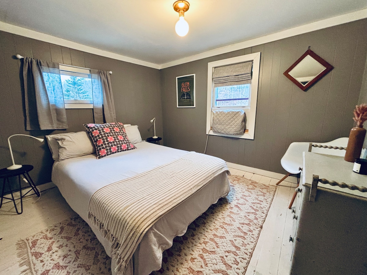 标准双人床卧室配备舒适的空调窗户单元，适合温暖的夜晚。