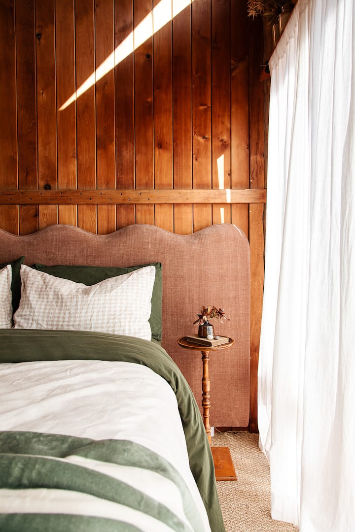 Wake up in a cosy queen bed dressed in luxurious linen, surrounded by the warmth of timber, and watch the sky's colours shift through the wide windows.