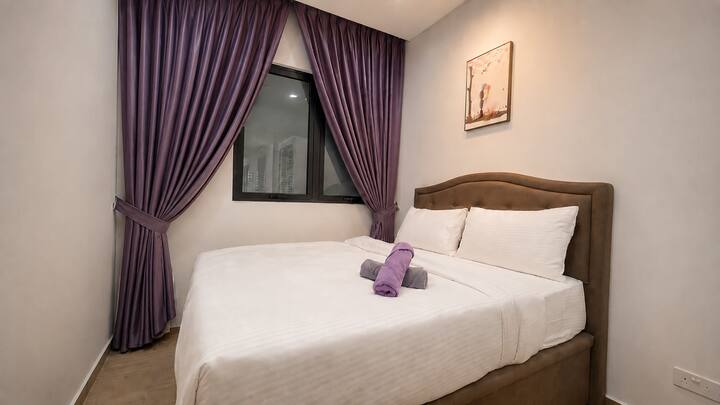 Elegant queen bedroom with cozy bedding and soft lighting, designed for a relaxing and comfortable stay.