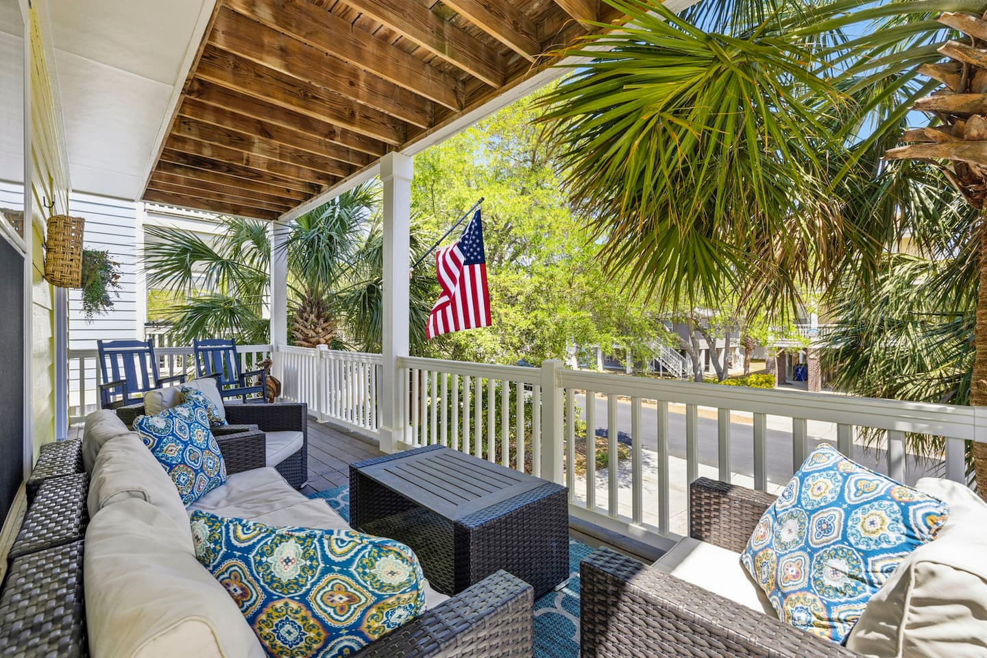 Step out to the balcony and claim your spot on the outdoor furniture. White railing, palm trees below, and the kind of view that makes coffee taste better.