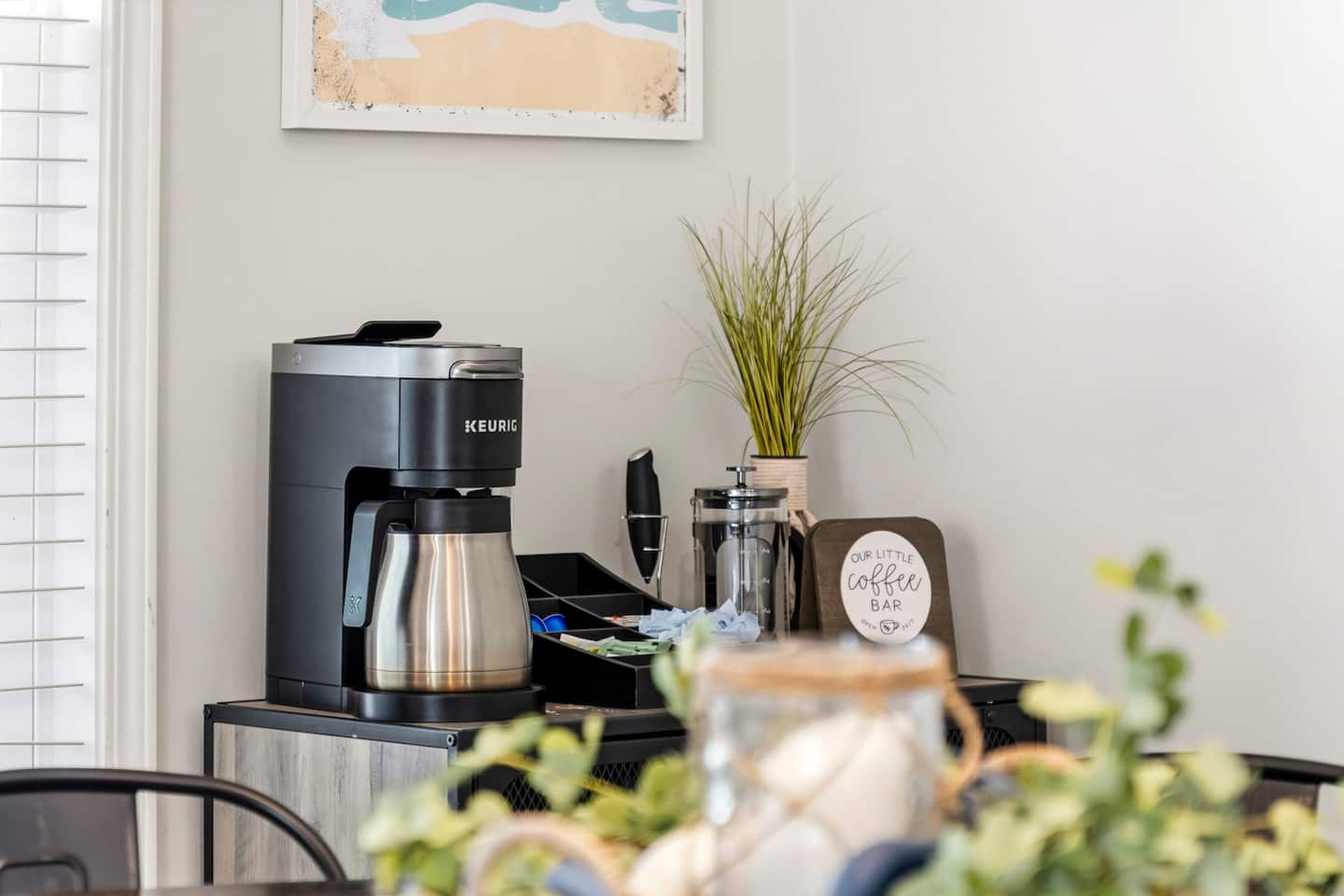 Pour your first cup at the dedicated coffee bar: Keurig, French press, and a sign that reads 'Our Little Coffee Bar,' because your host thought of everything.
