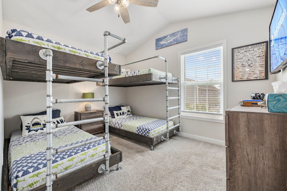 Send the kids to the shark bunk room: two industrial pipe-frame bunks, shark-themed bedding and wall art, and a PS4 upstairs to keep them busy.