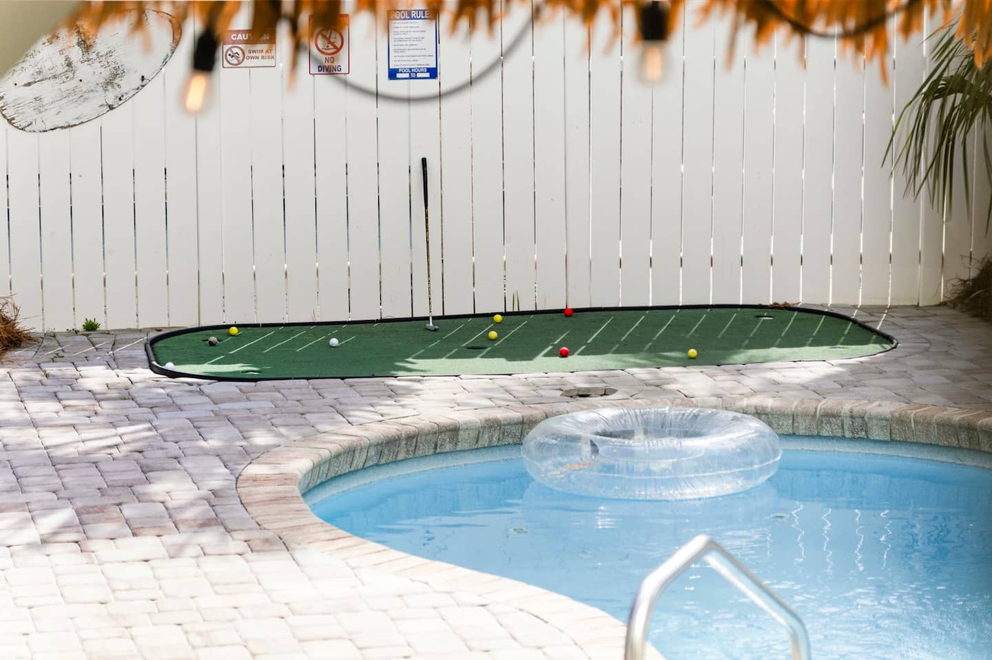 Challenge someone to a putting contest right beside the pool. Golf balls and putter already out, pool float drifting in the background.