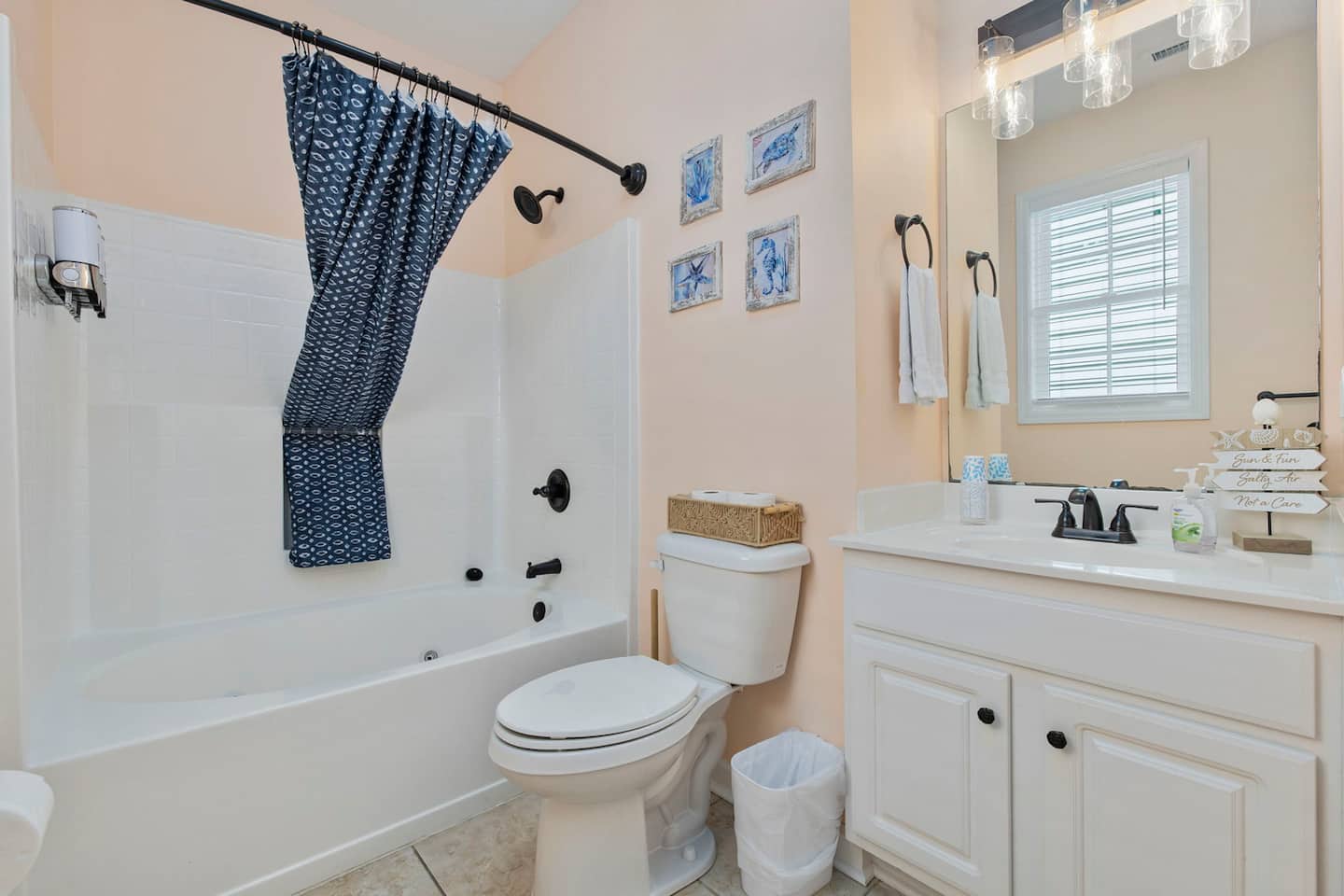 Start the morning in the main-floor en-suite. Tub and shower combo, white vanity, sea life art prints on the wall, everything fresh and ready.