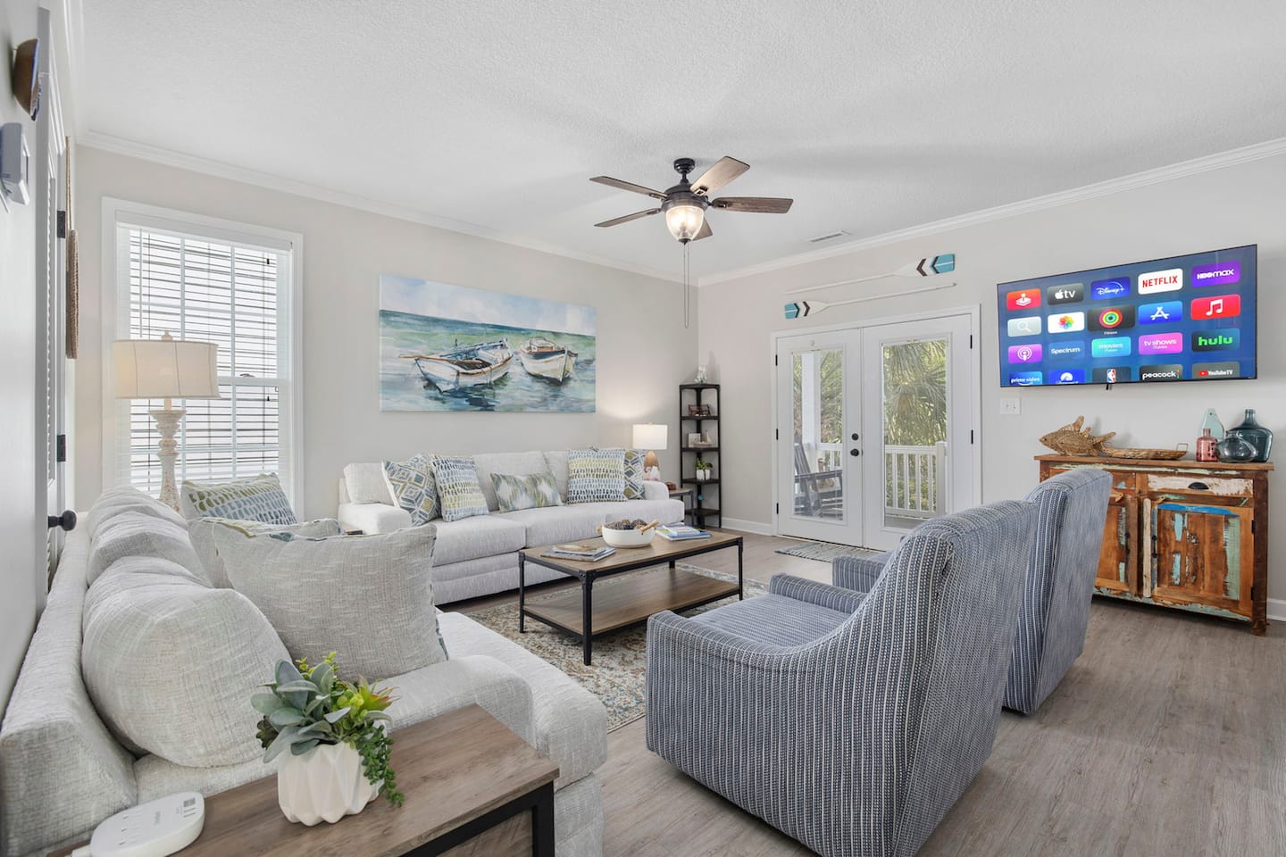 Stream any show on the wall-mounted 58-inch smart TV. Cable, Roku, and French doors to the porch right behind the sofas when fresh air is needed.