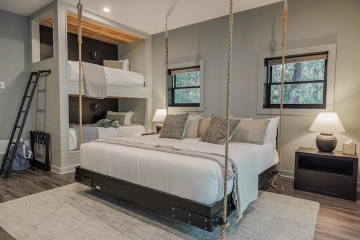 The rope-suspended king hanging bed from Four Oak Bed Swings is the centerpiece — and the kids will absolutely lose their minds over it.
