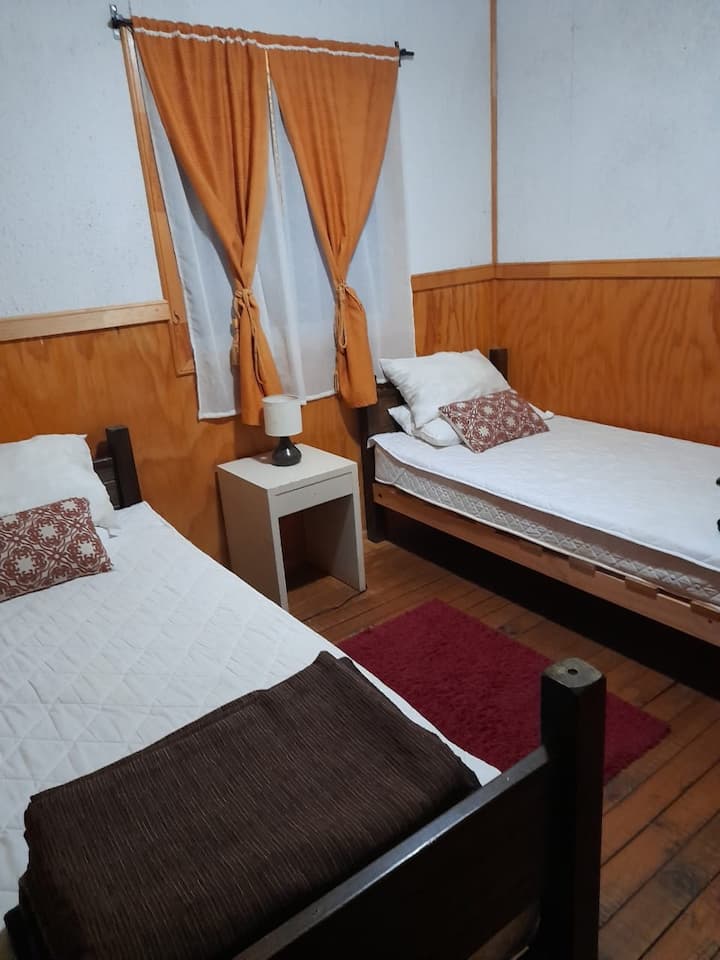 غرفة ثانية تضم سريرين بمقعد واحد 