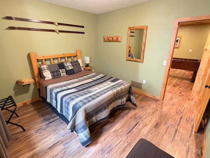 Lower level bedroom with a Queen bed and an ottoman that converts into a twin size bed. 