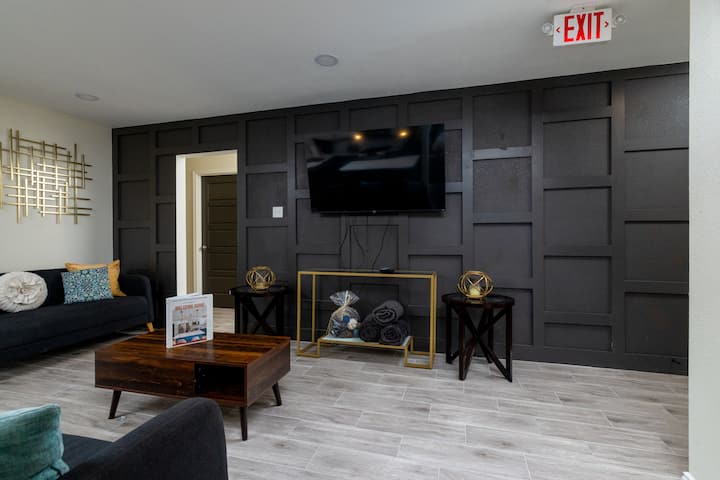 Sophisticated accent wall with a mounted flat-screen TV, elegant paneling, and chic gold accents.