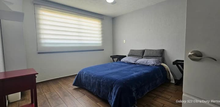 غرفة نوم ثالثة مع سرير بحجم كوين وخزانة ومروحة سقف وإحدى الستائر المزدوجة تعتيم.