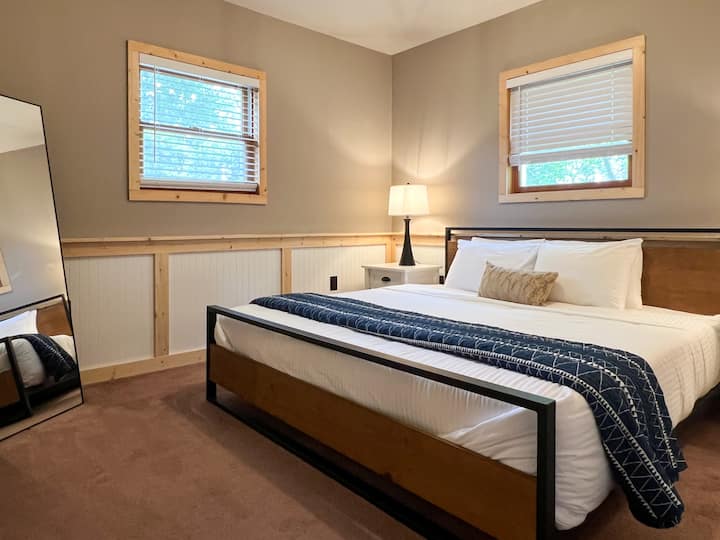 Main bedroom features a king sized bed and full length mirror 