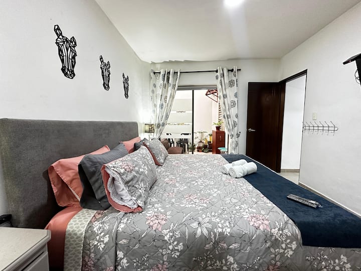 Habitación con cama King y acceso directo a un patio privado. Incluye Smart TV de 43”, ventilador, vestier y baño privado para mayor comodidad