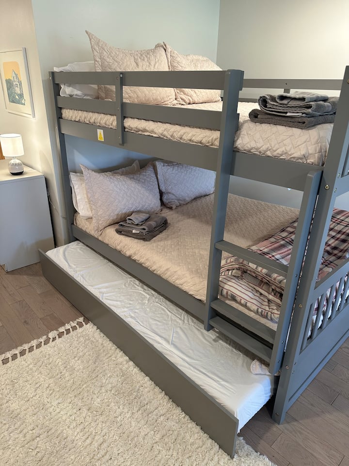 Litera nido tamaño queen ubicada en el sótano. Límite de peso de las literas superior: 200 libras