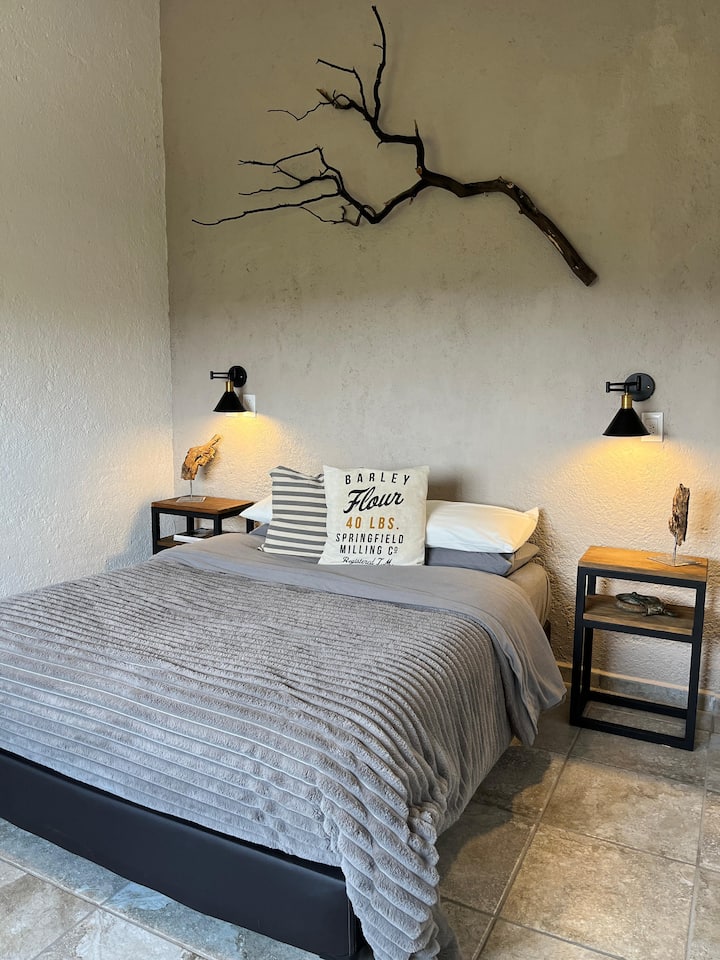 غرفة نوم مع سرير كوين وسرير أريكة لشخصين. 
