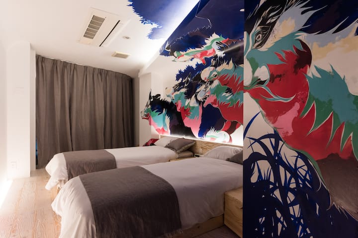 Twin bedroom with a calm atmosphere and an eye-catching, distinctive art wall.We provide a space where you can relax and unwind.