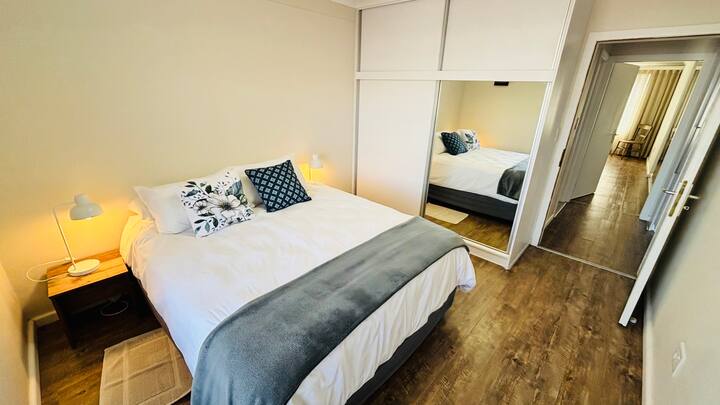 Un lit queen size confortable de haute qualité. Tables de chevet avec veilleuse, placard avec portes coulissantes miroir.