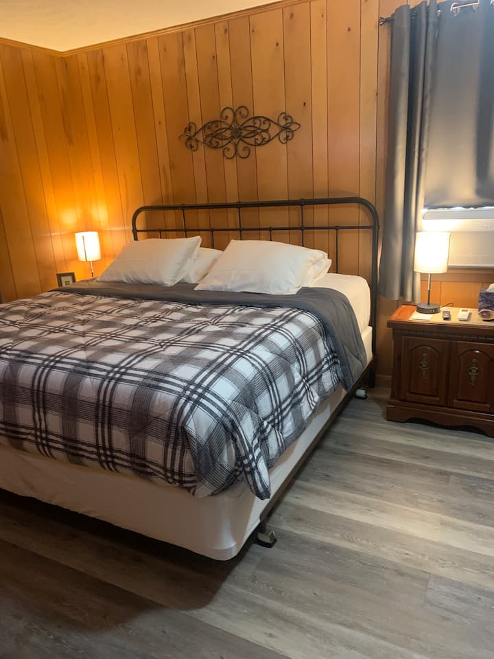 El dormitorio tiene una cama tamaño king con una televisión inteligente de 32 pulgadas en la pared y también un bonito vestidor.