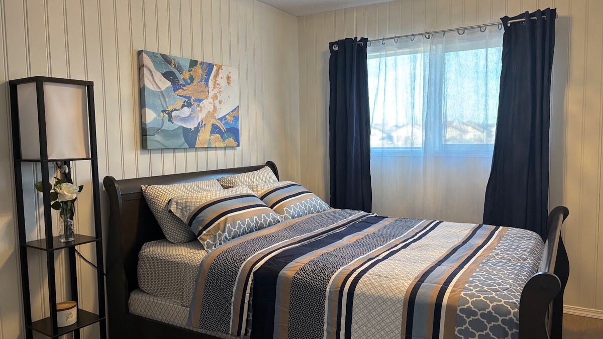 Потопете се в комфорта на тази красиво проектирана спалня. В стаята има двойно легло с чисти чаршафи и модерна раирана завивка. Големите прозорци пропускат много естествена светлина, смекчена от тъмни завеси за тези, които предпочитат да спят.