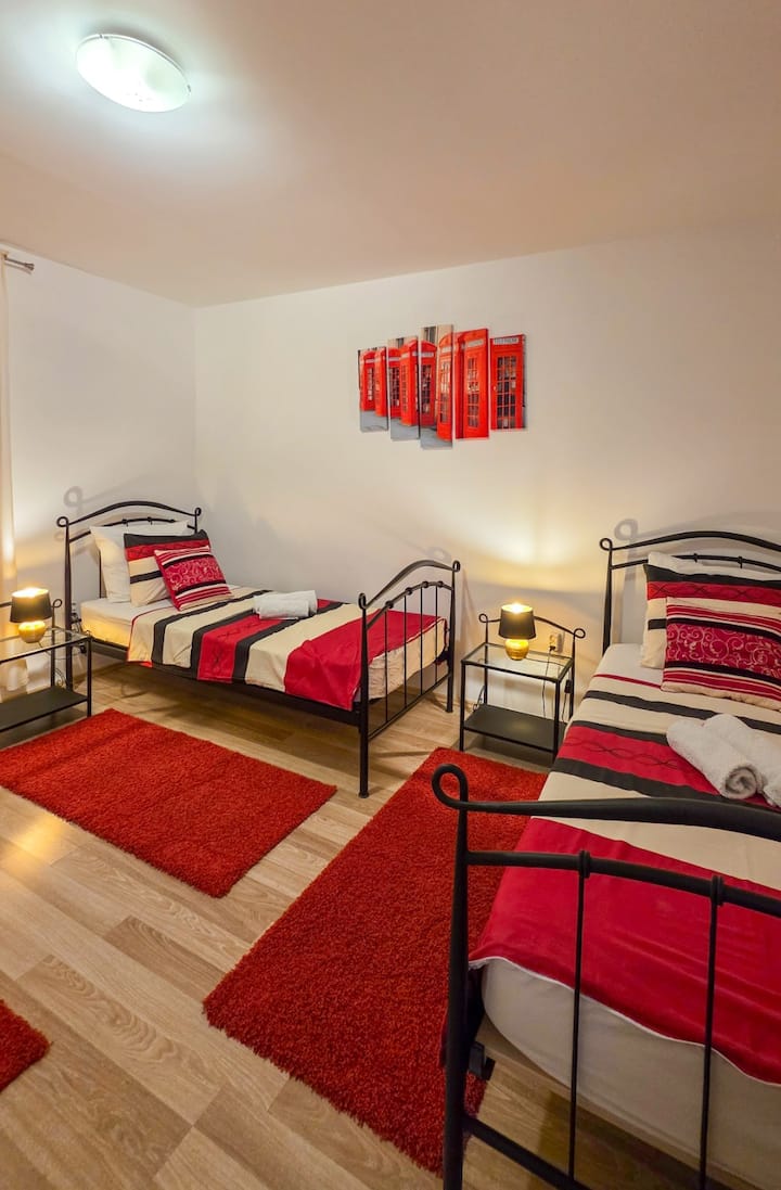 Comfortable bedroom with three single beds, bedside lamps and natural light. A practical sleeping space for three guests, ideal for children, friends or family members.