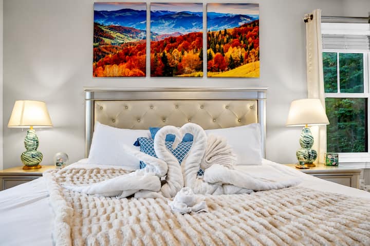 Step into serenity and romance in the Master Bedroom at Hideaway Between Lakes. From the heart-shaped swan towels to the breathtaking mountain views. Book your escape today—your dream getaway is just a click away!