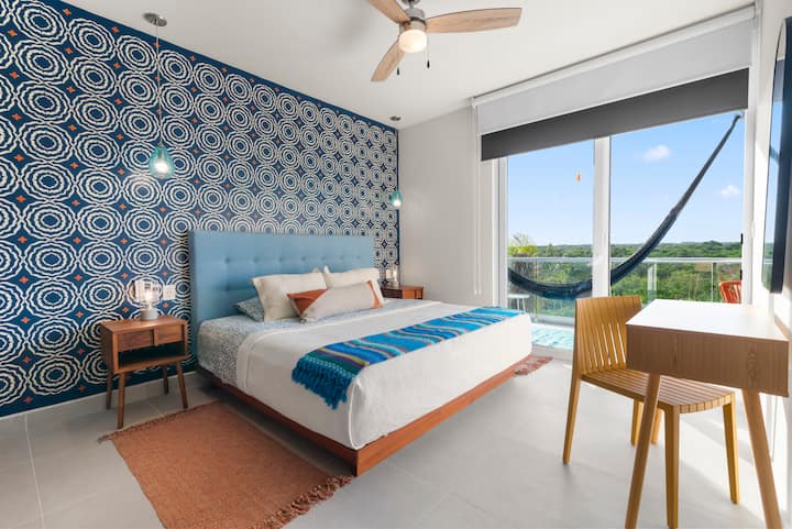 Disfrute de un dormitorio espacioso con una cama king, un espacio de trabajo para teletrabajar y acceso directo a su balcón privado. Disfrute de la comodidad con aire acondicionado, un ventilador de techo y persianas que oscurecen la habitación, además de interruptores de luz y tomacorrientes junto a la cama.