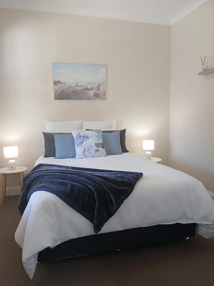 Disfruta de la comodidad de la ropa de cama y las sábanas de calidad. Cama tamaño queen equipada con protector de colchón con infusión de carbón, manta eléctrica y cubrecolchón. Almohadas y doonas adicionales disponibles. Toca las lámparas de noche. Portaequipajes para la maleta.