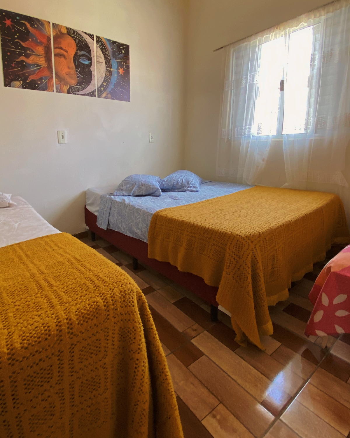 客房可欣赏街景，配有一张双人床和一张单人床 