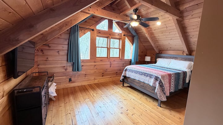 Loft bedroom with queen bed and newly added blackout curtains.