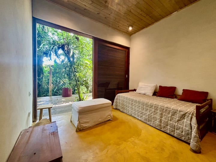 غرفة في الطابق الأرضي بإطلالة جانبية على السطح. يحتوي على سرير واحد وسرير مزدوج لشخص آخر.