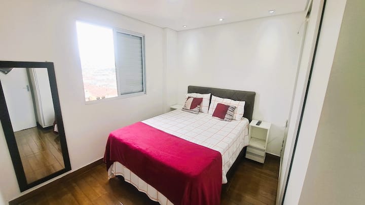 Удобна спална соба со брачен кревет, 32-инчен LED телевизор, поглед кон пристаништето Сантос, клима уред и вграден плакар.