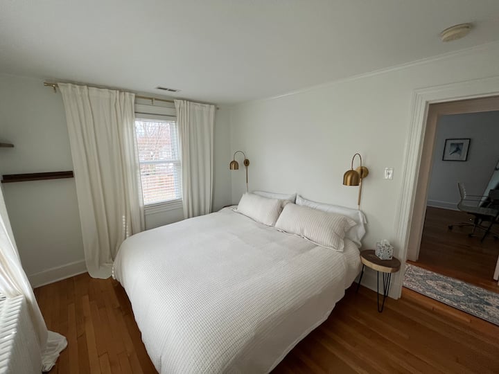 غرفة نوم في الطابق الثاني تحتوي على سرير كبير وخزانة ملابس. 