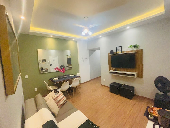 всекидневна/трапезария с диван и маса с 4 стола, контакти до масата и диван, вентилатор на тавана и лаптоп . 