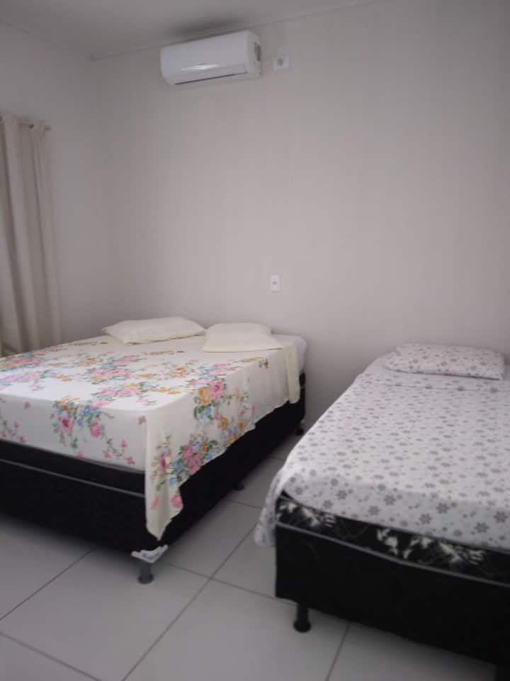 Chumba chenye kitanda cha watu wawili na kitanda cha mtu mmoja.