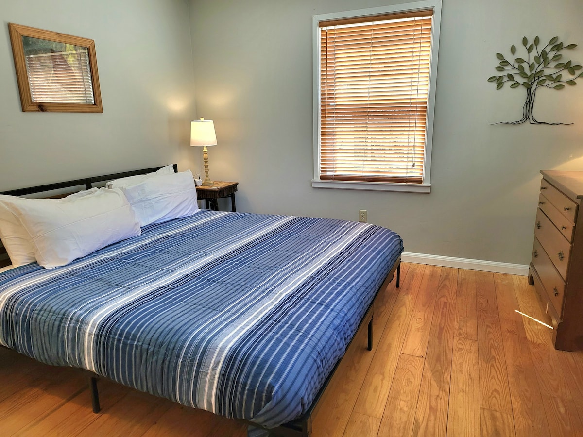 King bed (max 2 people), ceiling fan, dresser, and armoire with hanging space located on 1st floor next to the full bathroom. Great for taking a quick nap after tossing a line for trout  and before grilling the tasty trout 