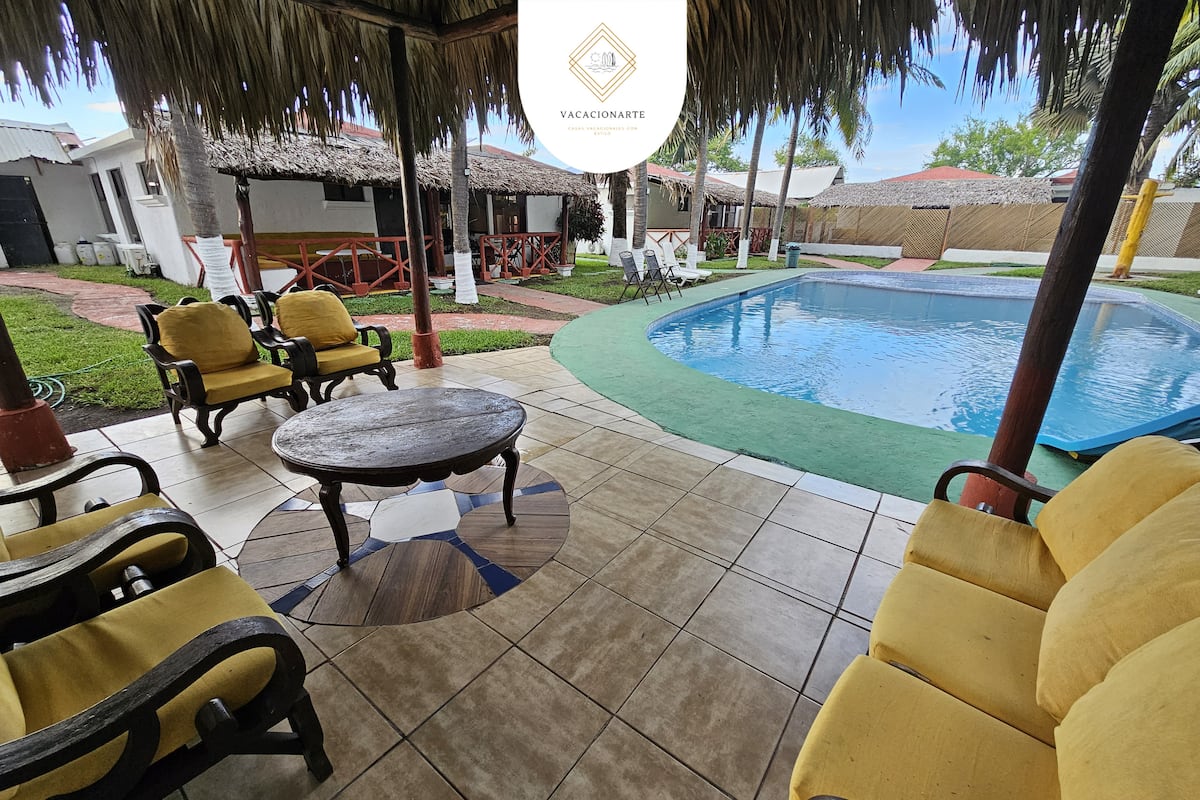 Área de piscina rodeada de palmeras en Monterrico