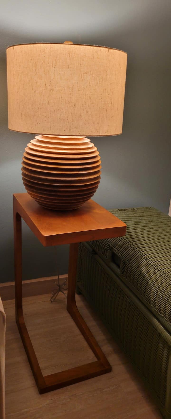 The  polished porceline tile flooring and  wood base foe the lamp and side table bring warmth and texture, grounding the space in natural elements