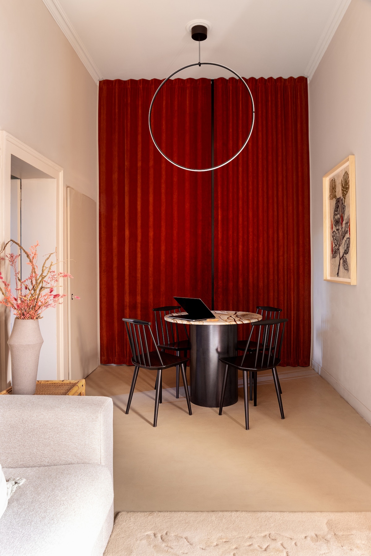 Living room composed of a sofa bed and a dining area. The 'Paulo' table, designed by the hosts for Collezione Caleido, is made of Brazilian marble with an iron base. Serving as a backdrop is the Dooor textile wall: a real reinforced wall with a lock.