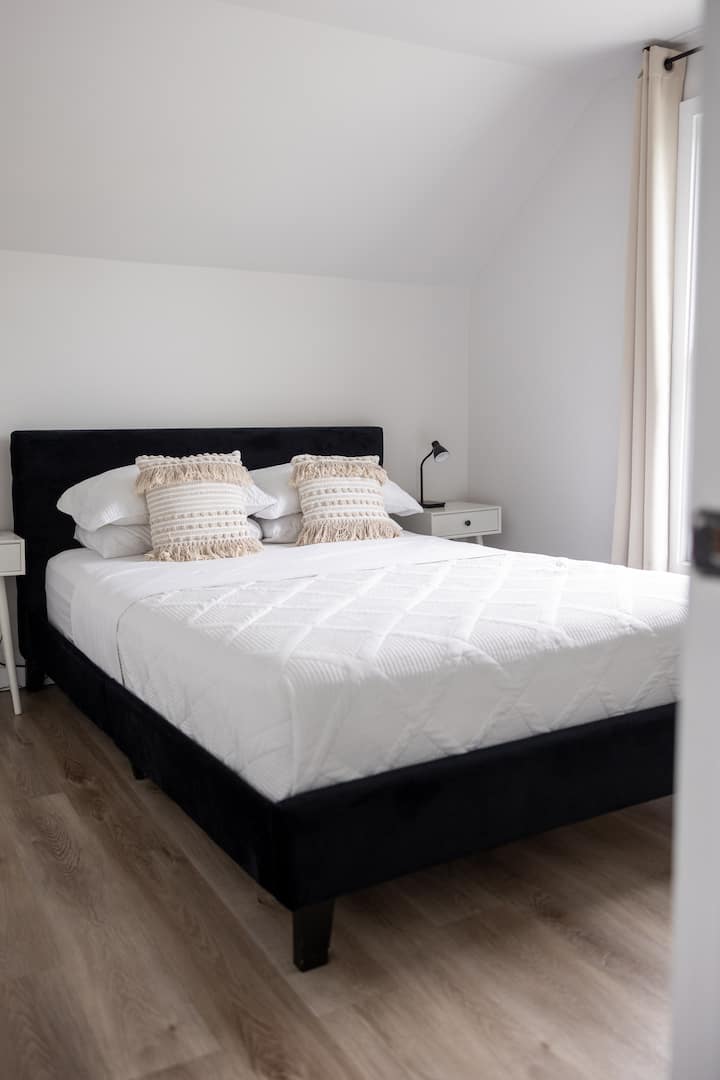 Bright, modern bedroom with plush bedding and natural light