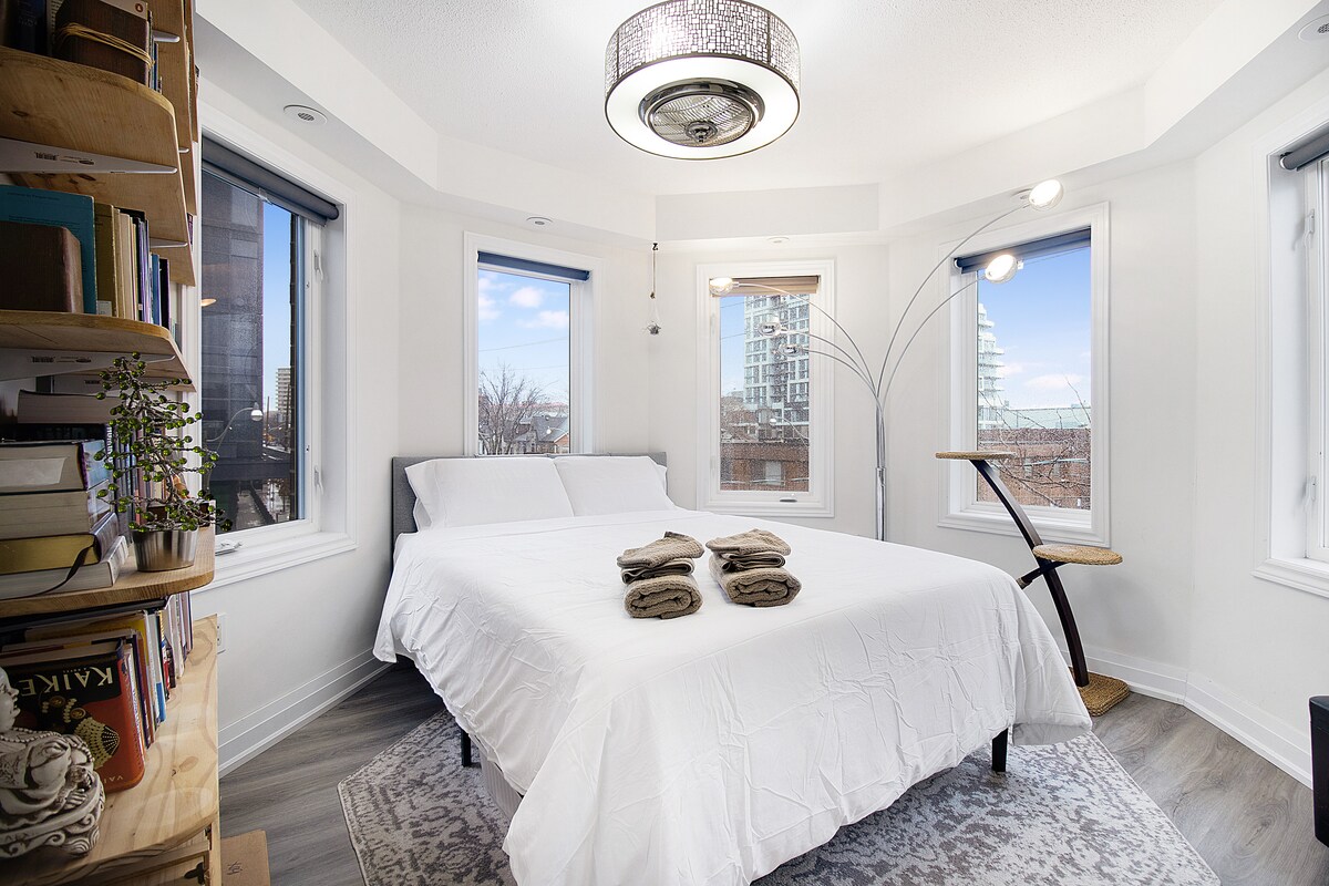 标准双人床、衣橱（含衣架）、带笔记本电脑/充电器插头的工作区。
卷帘（有些光线透过）
吊灯/风扇（遥控）